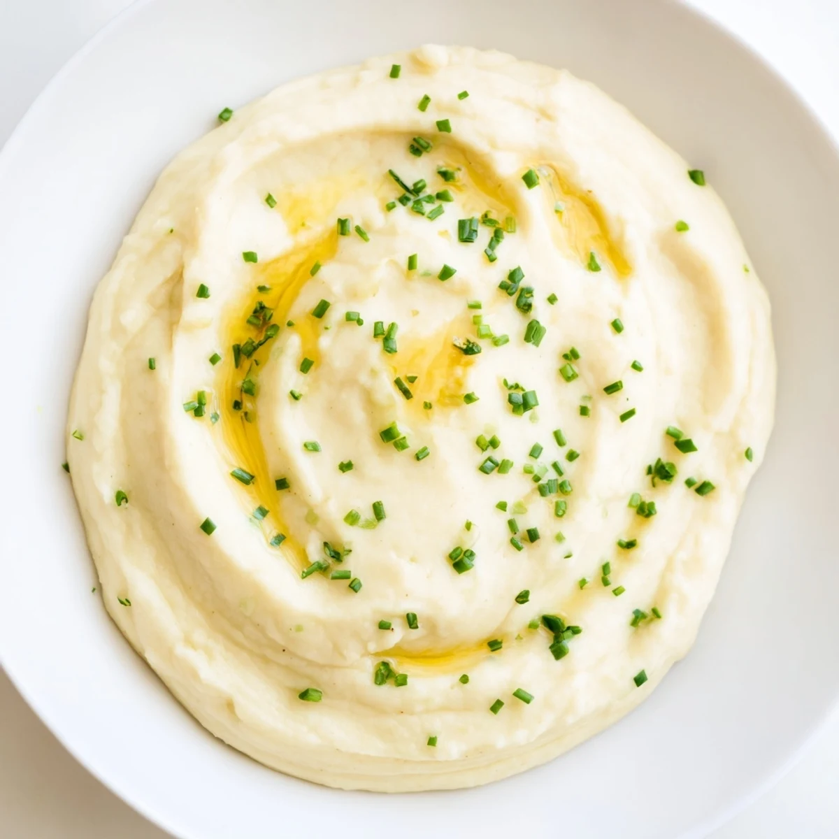 Fluffy Roasted Garlic Mashed Cauliflower, smooth and rich, topped with fresh chives, a great side!