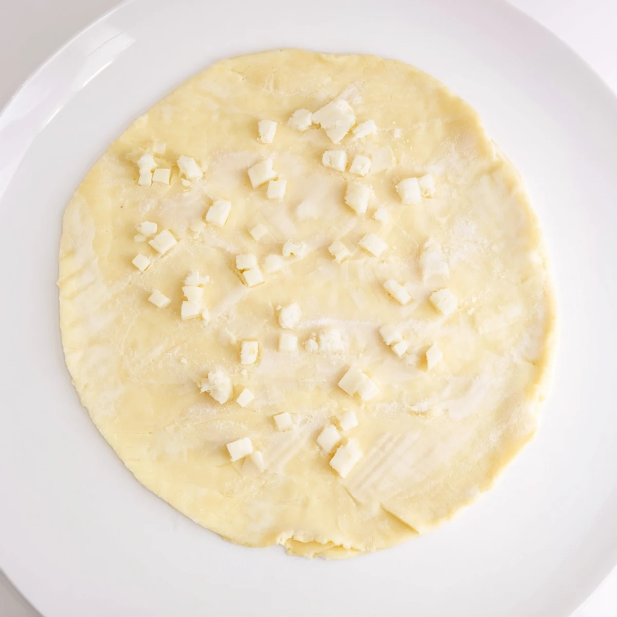 Flaky, chilled savory pastry dough ready to be rolled out onto a floured surface for baking.