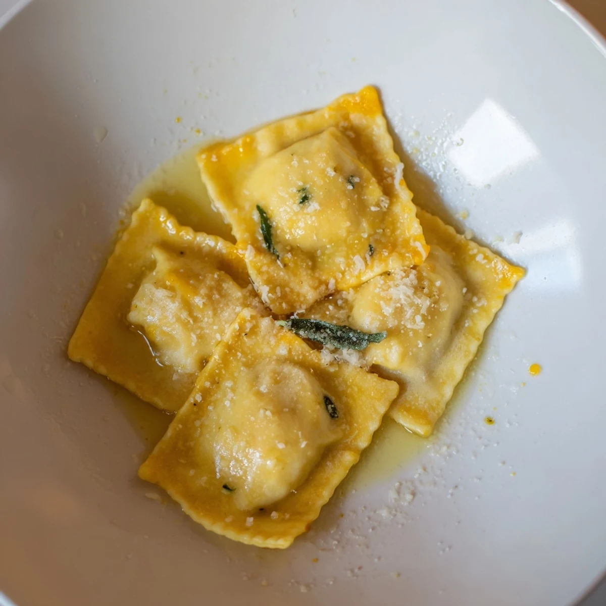 Golden brown Squash Ravioli, swimming in a rich, sizzling brown butter sauce with fresh sage.