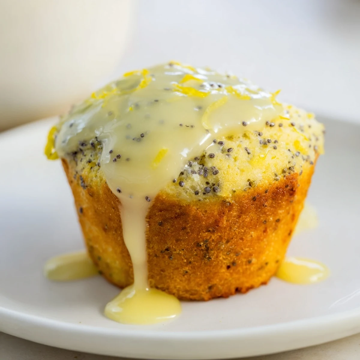 Fluffy Lemon Poppy Seed Muffins, still warm from the oven, drizzled with bright lemon icing.