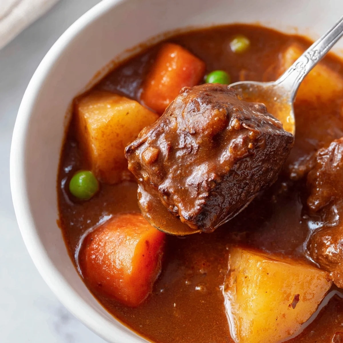 Slow Cooker Beef Stew in a rustic bowl with carrots, potatoes, and peas, garnished with fresh thyme.
