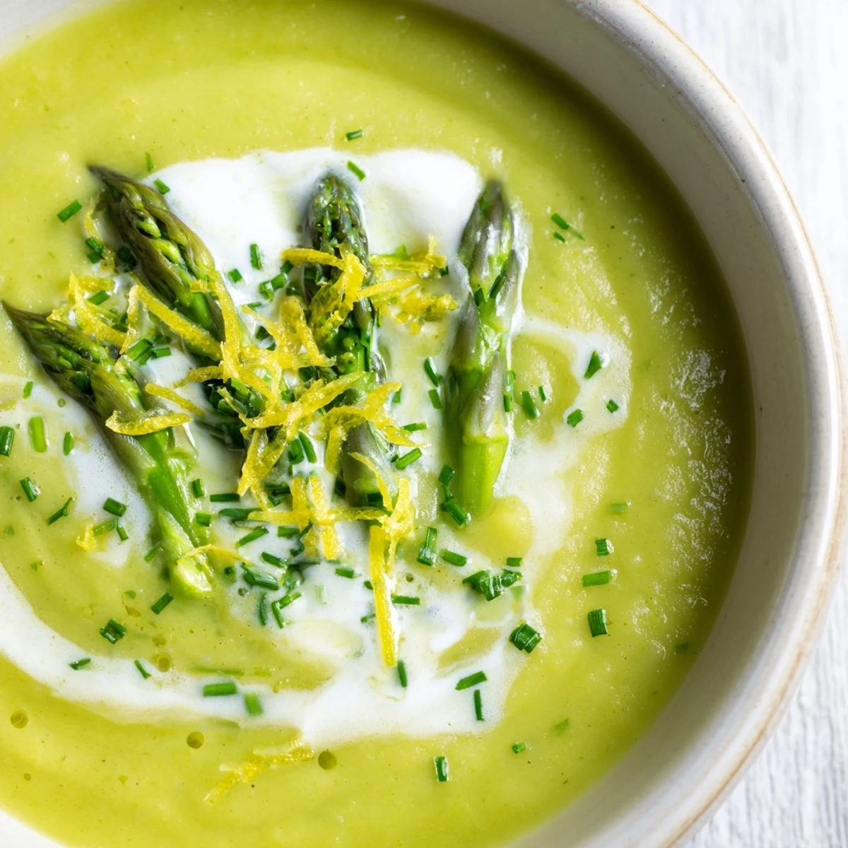 Silky Creamy Asparagus Soup with Lemon served alongside rustic bread, perfect for a bright springtime lunch.