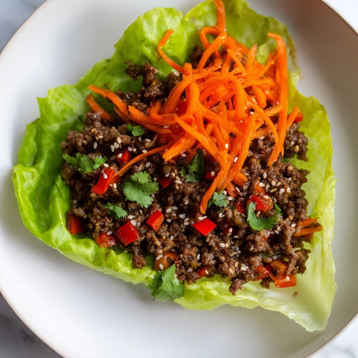 A close-up view of delicious Beef Lettuce Wraps with Hoisin Sauce and Ginger, garnished with cilantro and ready to be folded for a savory bite.
