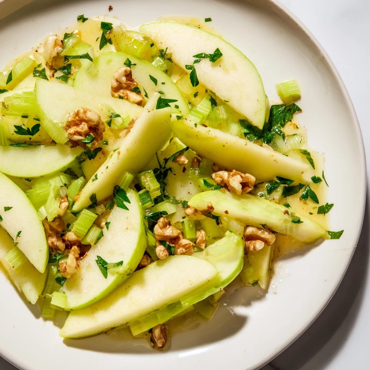 Freshly sliced green apples and celery mixed with toasted walnuts in a light vinaigrette for the Green Apple and Celery Salad with Walnuts.