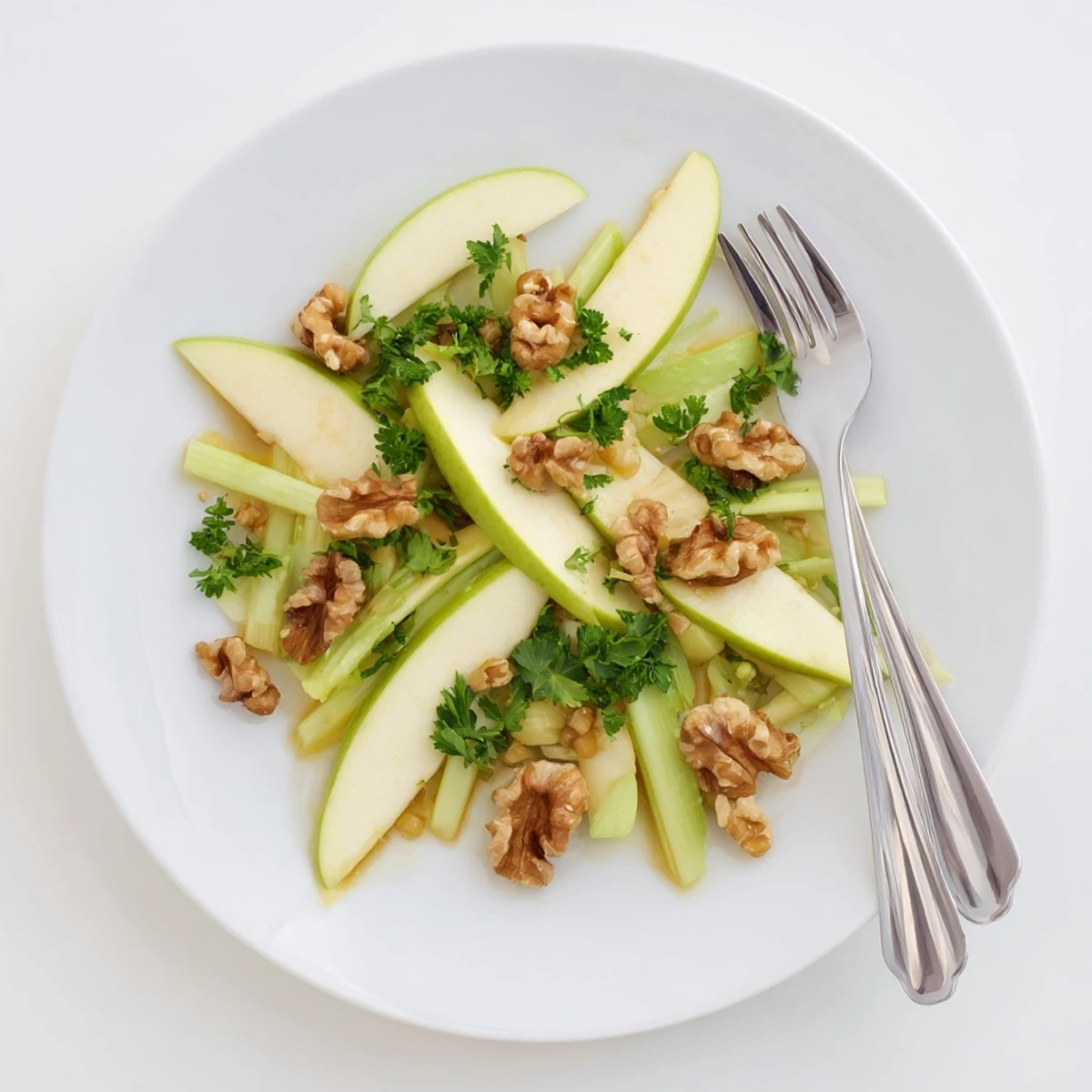 A vibrant bowl of Apple and Celery Salad with Walnuts, featuring crisp greens and toasted nuts ready for a healthy lunch.