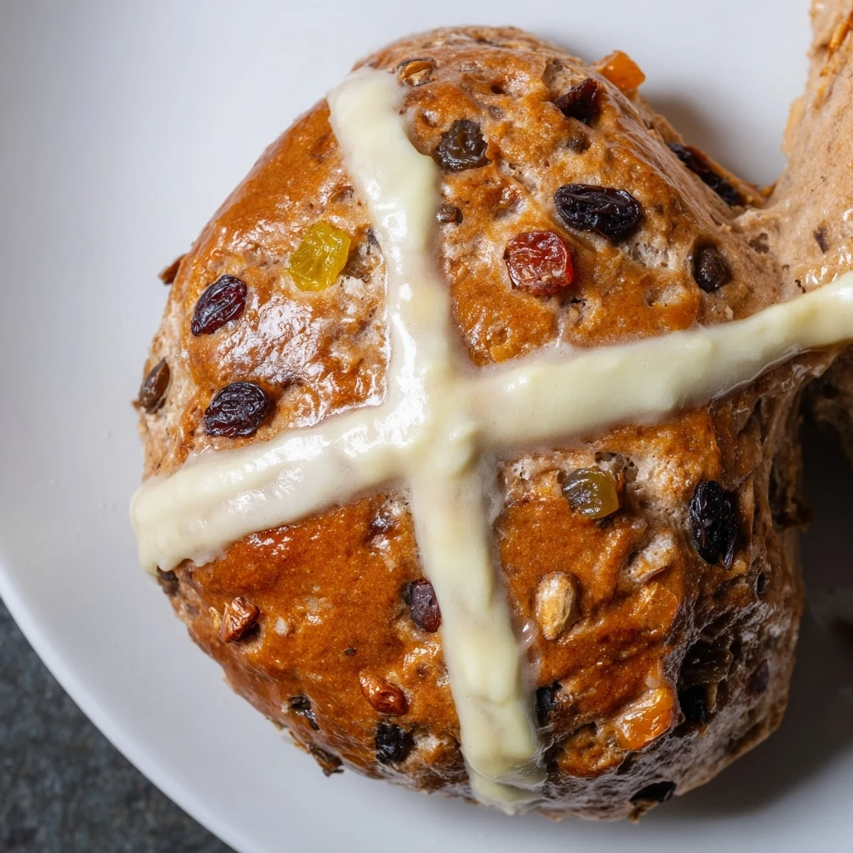 Freshly baked Easter Hot Cross Buns cooling on a wire rack, accompanied by a cup of tea for a traditional holiday breakfast.