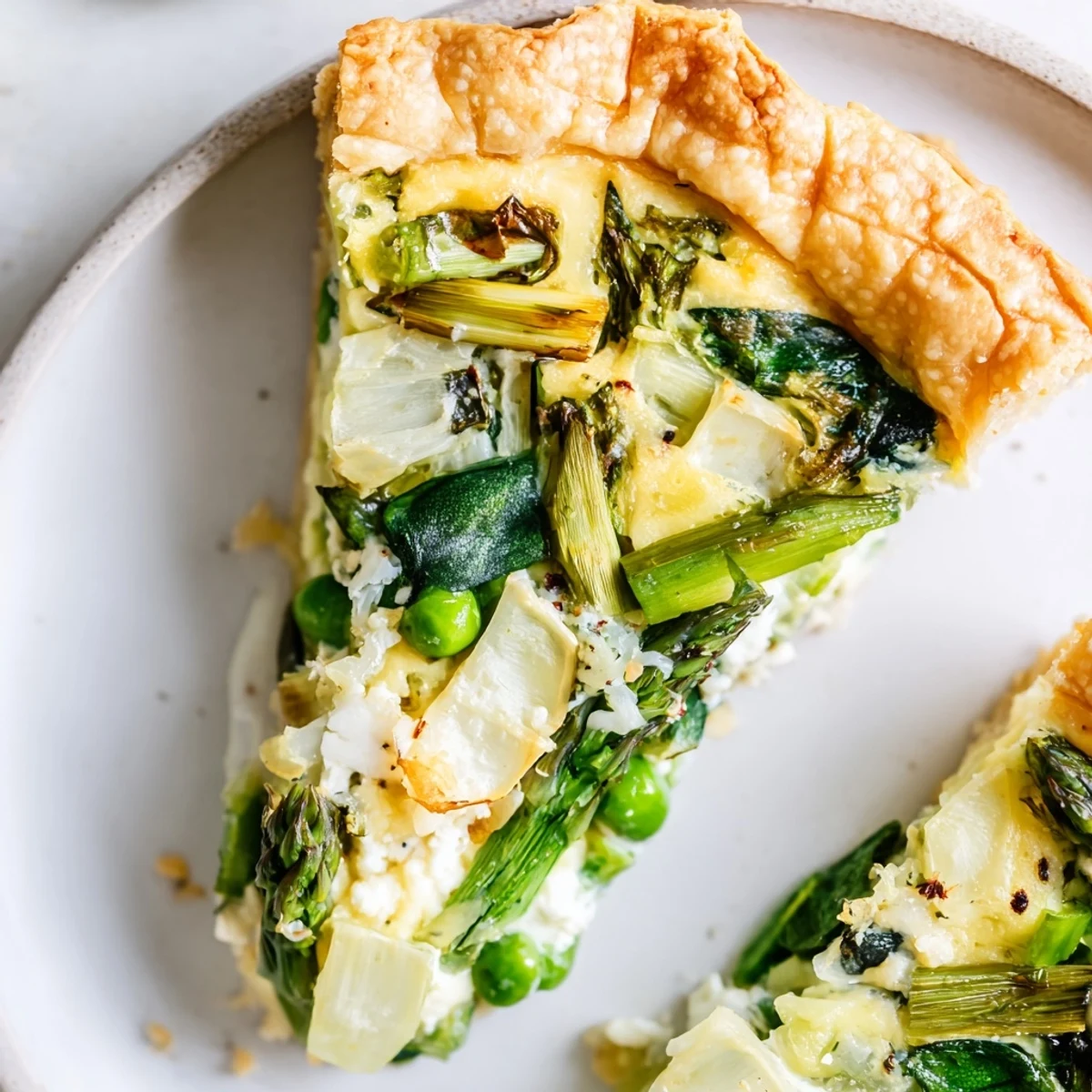 Freshly baked Spring Vegetable Quiche with Flaky Crust shows a golden, flaky crust and a colorful filling of spring vegetables.