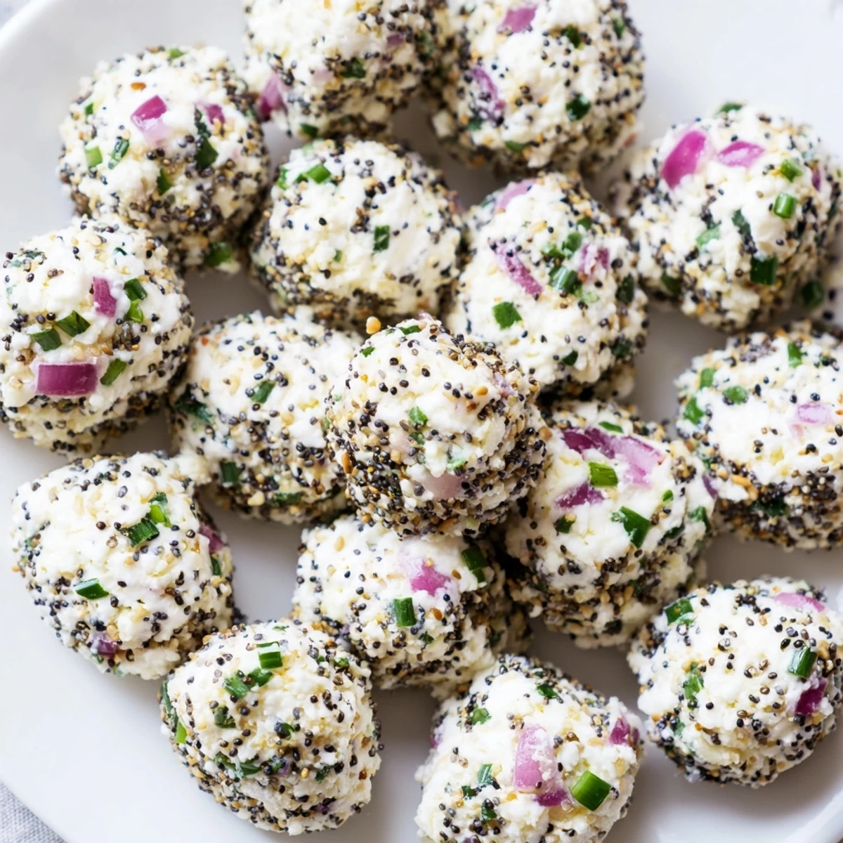 Soft white cottage cheese bites coated in savory everything seasoning, served as a healthy high-protein party appetizer.