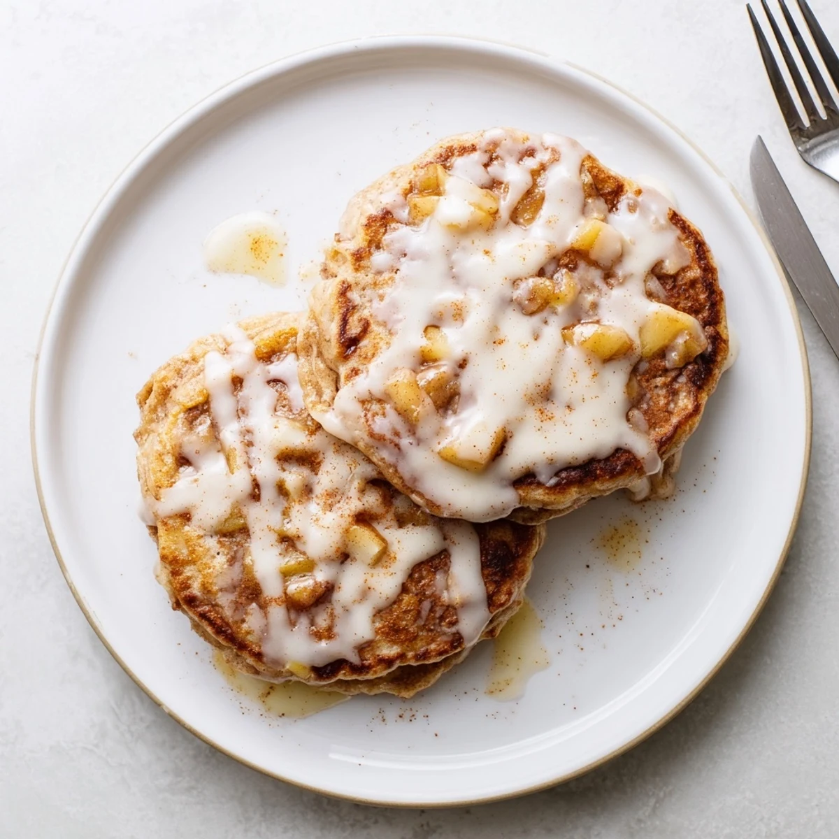 A close-up of Apple Fritter Pancakes topped with glaze, perfect for a cozy weekend breakfast.
