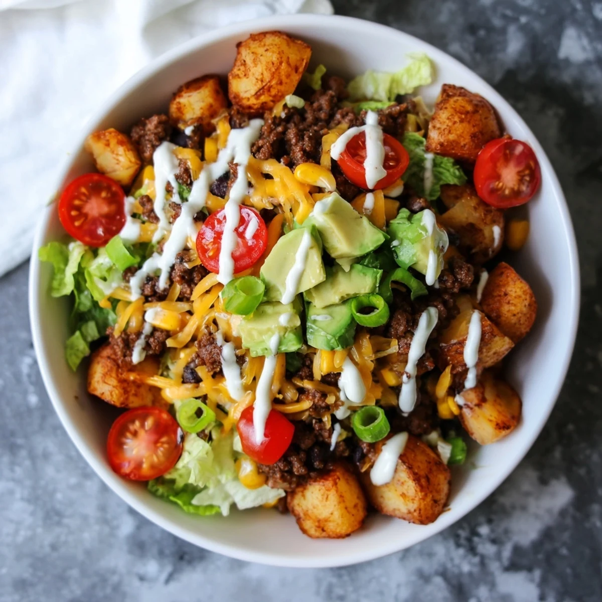 Golden crispy potatoes and spiced beef fill this Loaded Potato Taco Bowl, garnished with avocado and lime for a fresh finish.