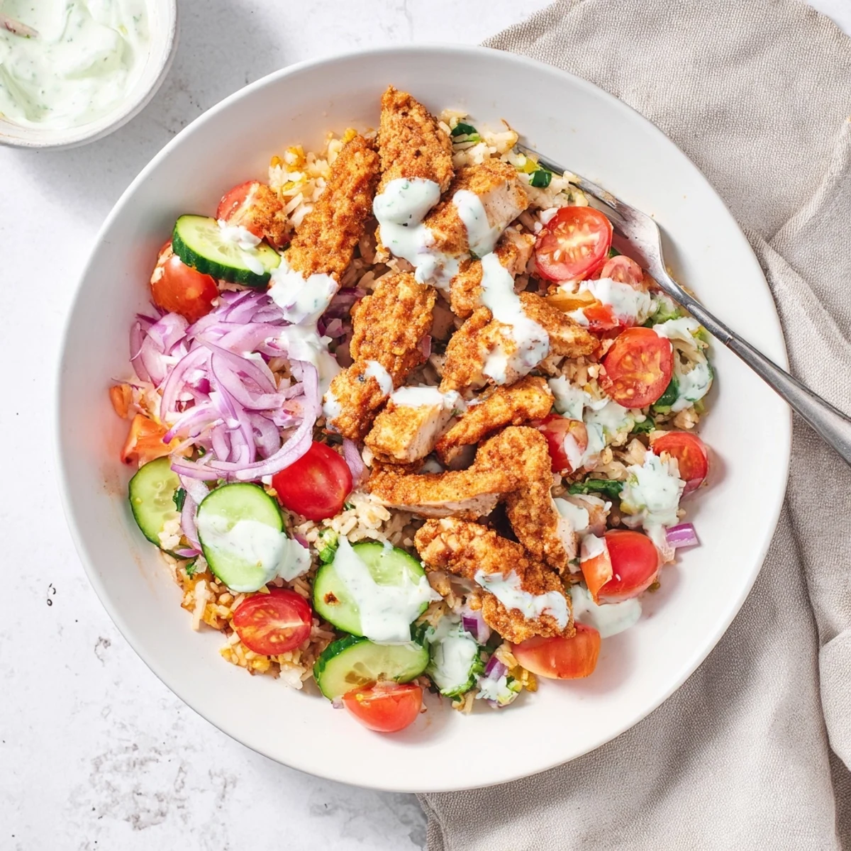 This Chicken Shawarma Crispy Rice Salad showcases crunchy rice, tender chicken, and a tangy Greek yogurt drizzle on a platter.