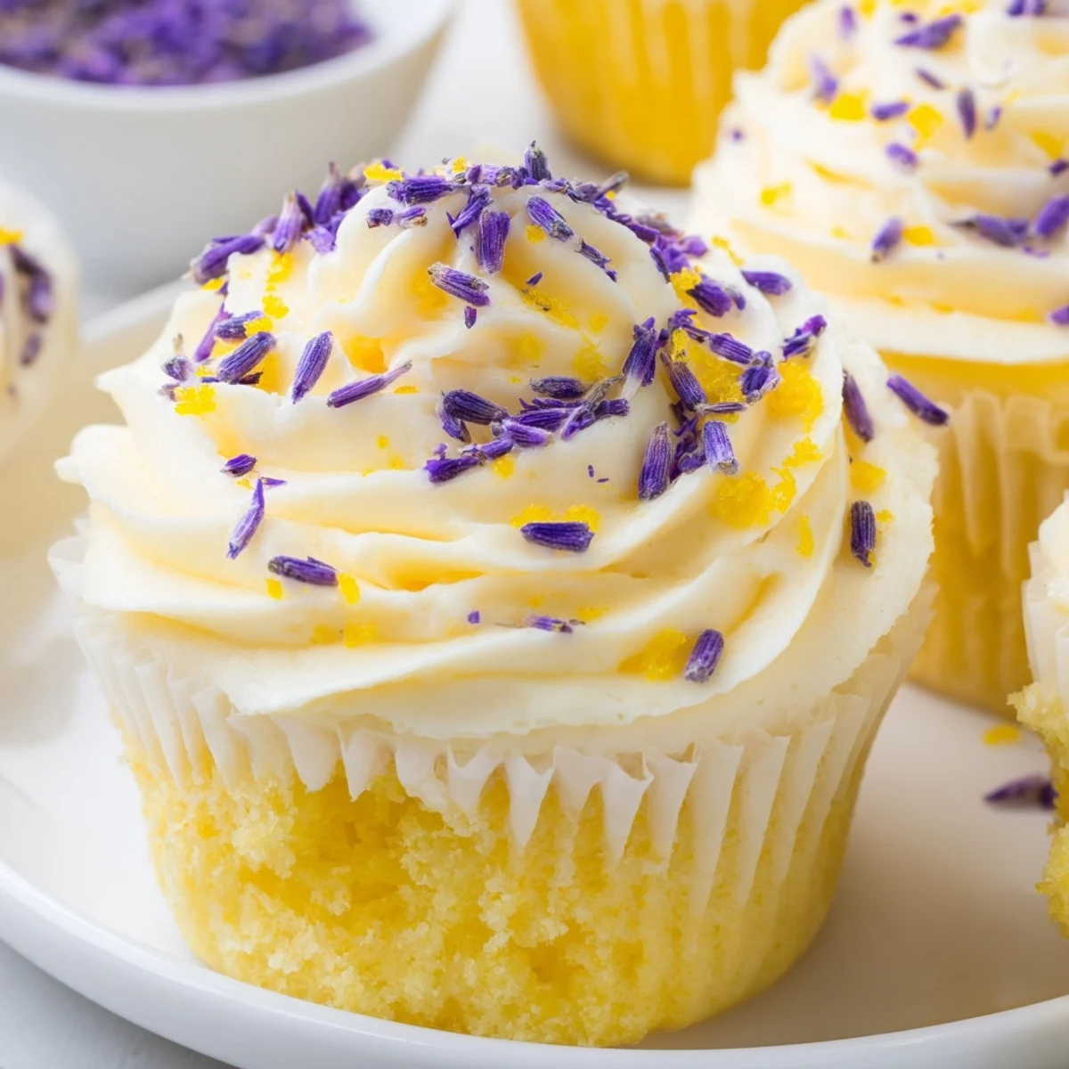 Freshly baked lemon lavender cupcakes with aromatic floral notes, finished with smooth buttercream and citrus zest on a marble surface.