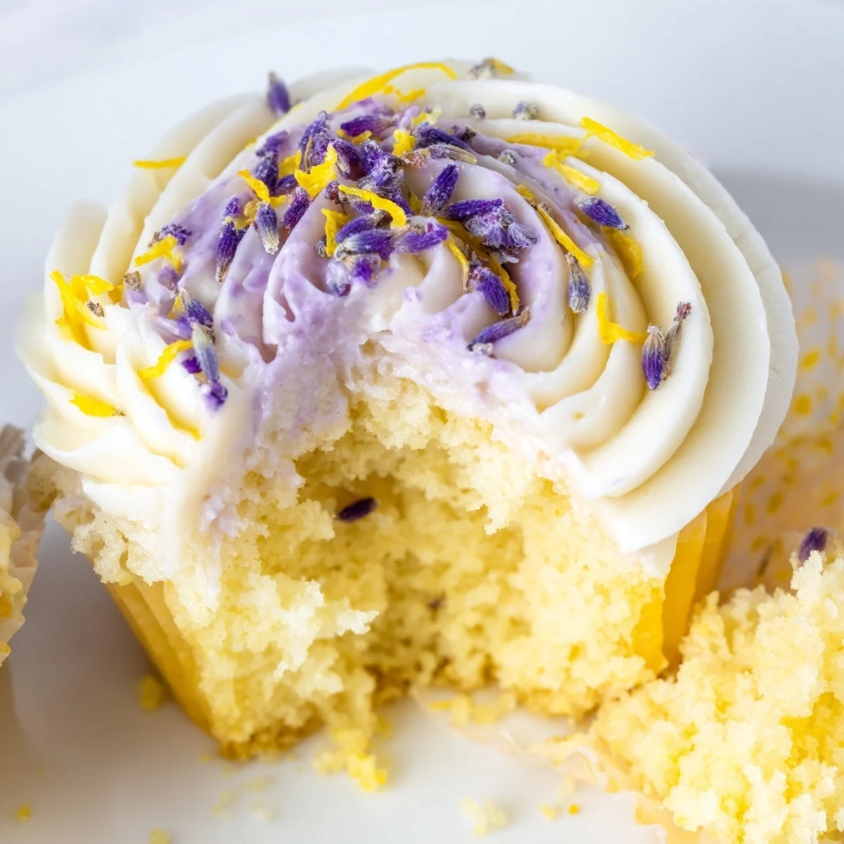 Golden lemon lavender cupcakes with light crumb texture, piped with tangy lemon frosting on a rustic wooden serving board.