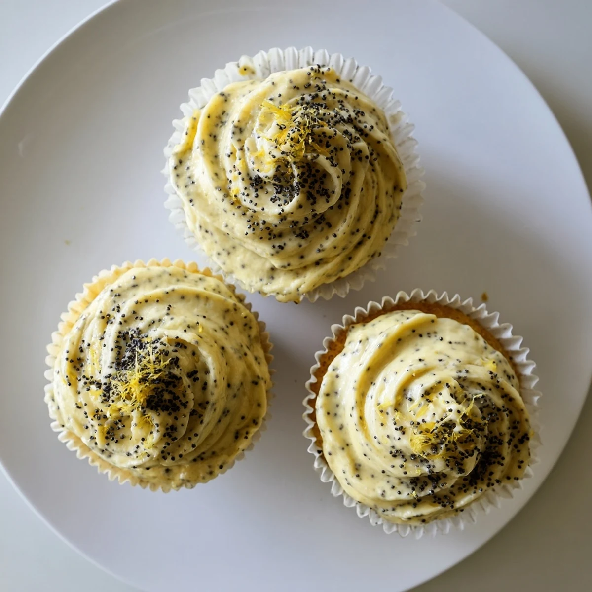 Freshly baked lemon poppy seed cupcakes swirled with tangy cream cheese frosting