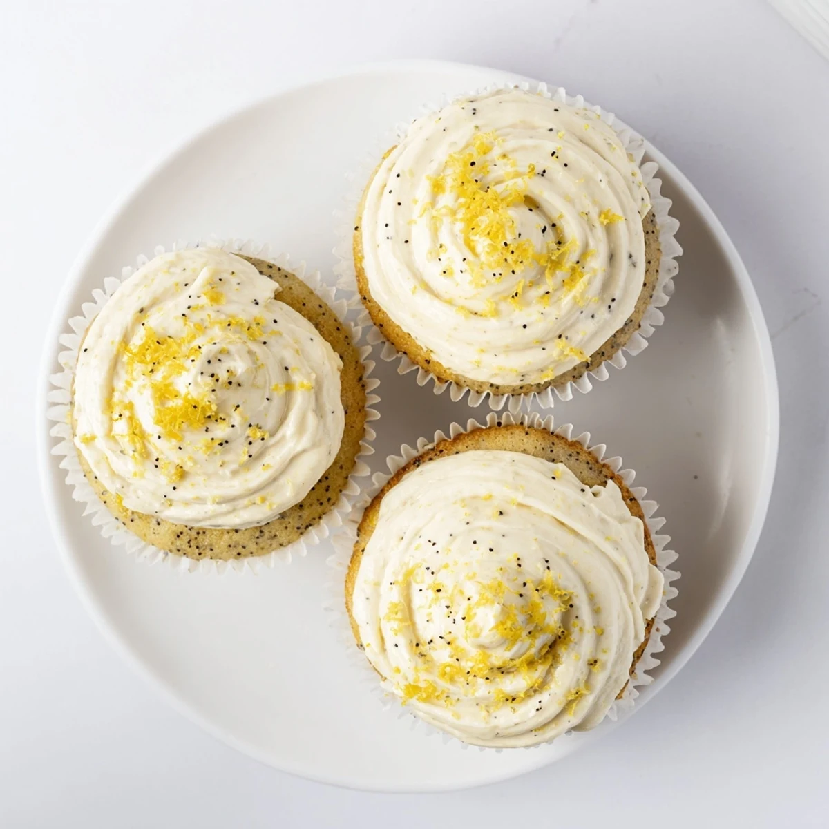 Moist lemon poppy seed cupcakes with creamy frosting and crunchy poppy seed speckles