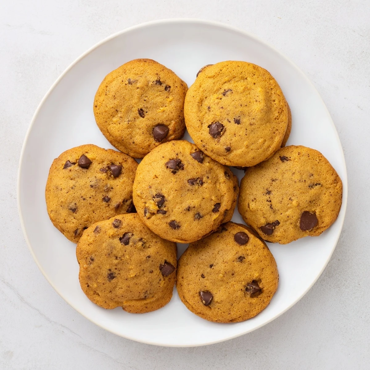 Warm homemade pumpkin spice chocolate chip cookies fresh from the oven with gooey centers