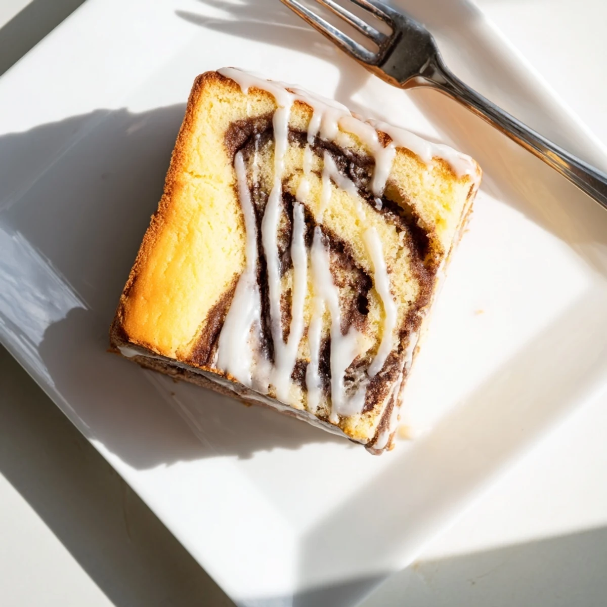 Breakfast cinnamon roll cake featuring marbled spice swirls and drizzled powdered sugar icing