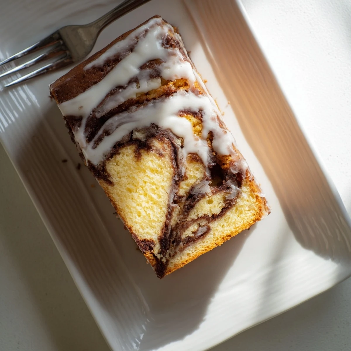 Soft buttery cake swirled with cinnamon sugar layers topped with silky vanilla frosting