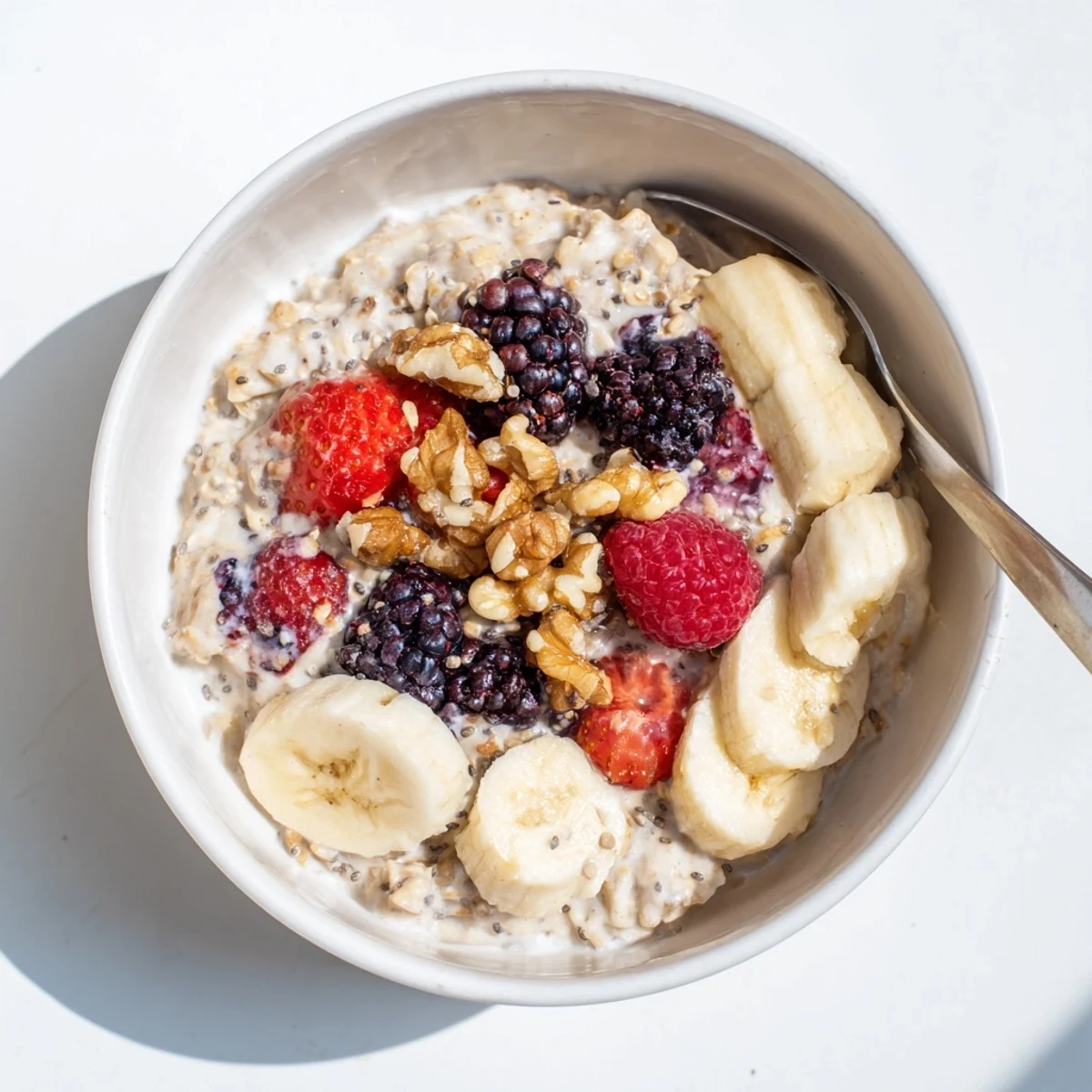Ready-to-eat brown sugar overnight oats sprinkled with chia seeds and sliced banana in a white bowl