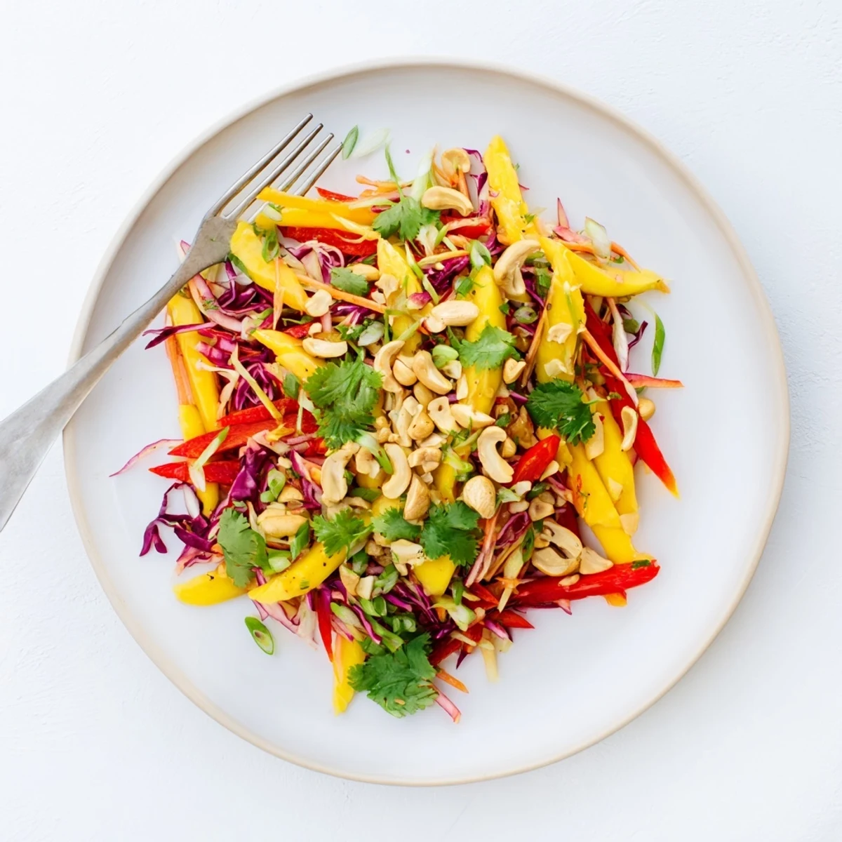 Fresh mango slaw topped with toasted cashews and fragrant cilantro leaves