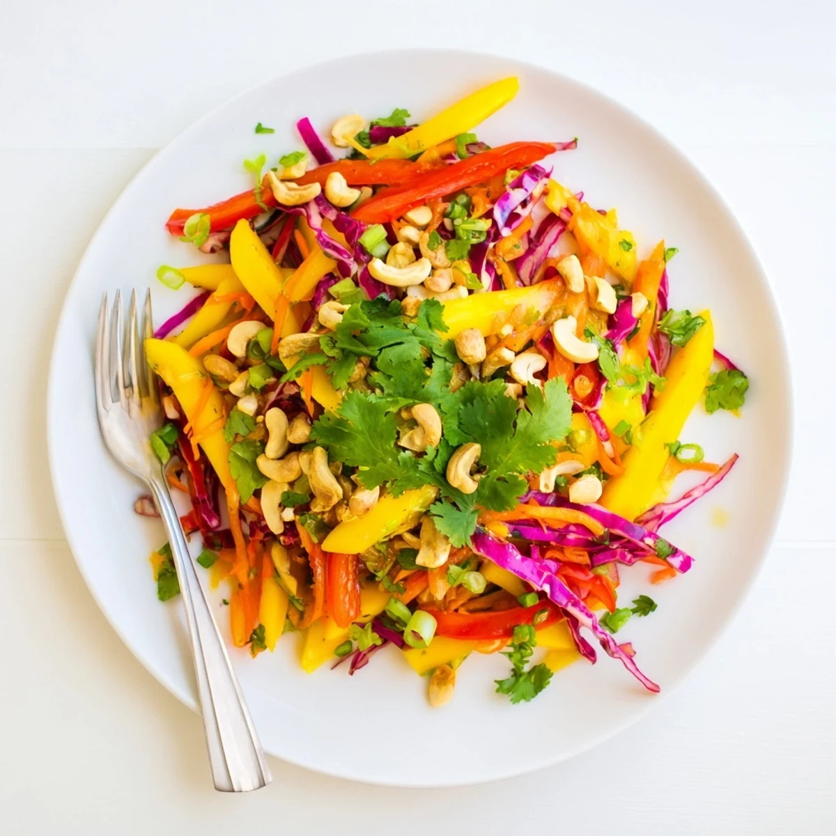 Vibrant mango slaw bowl featuring julienned vegetables and tangy lime honey dressing