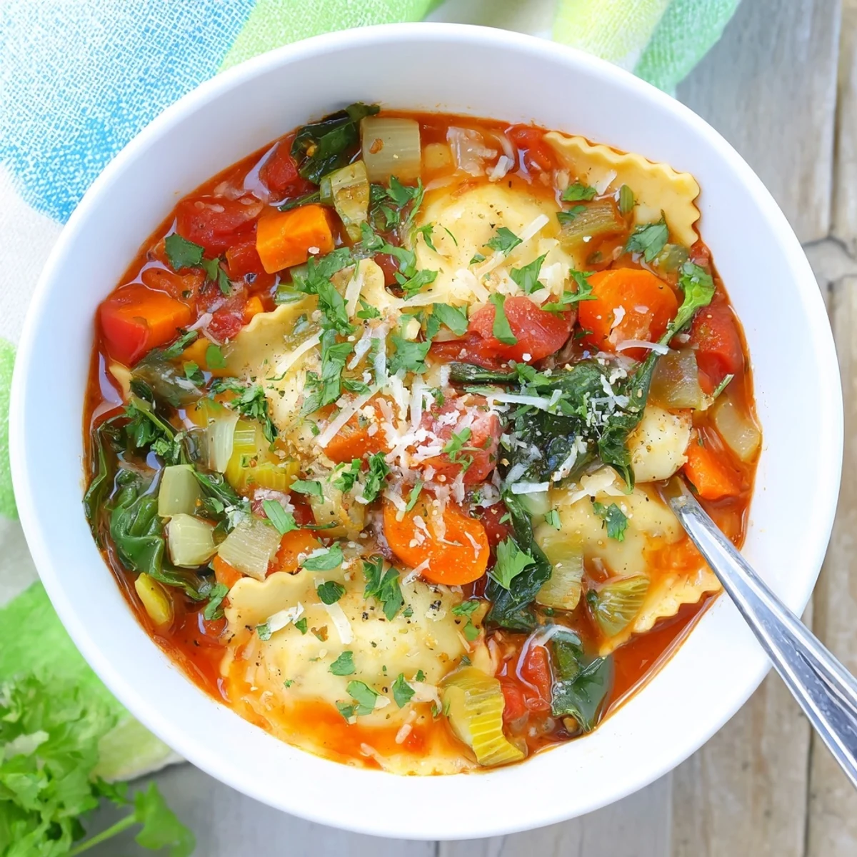Steaming bowl of Easy Tuscan Ravioli Soup featuring tender ravioli, wilted spinach, and grated Parmesan garnish