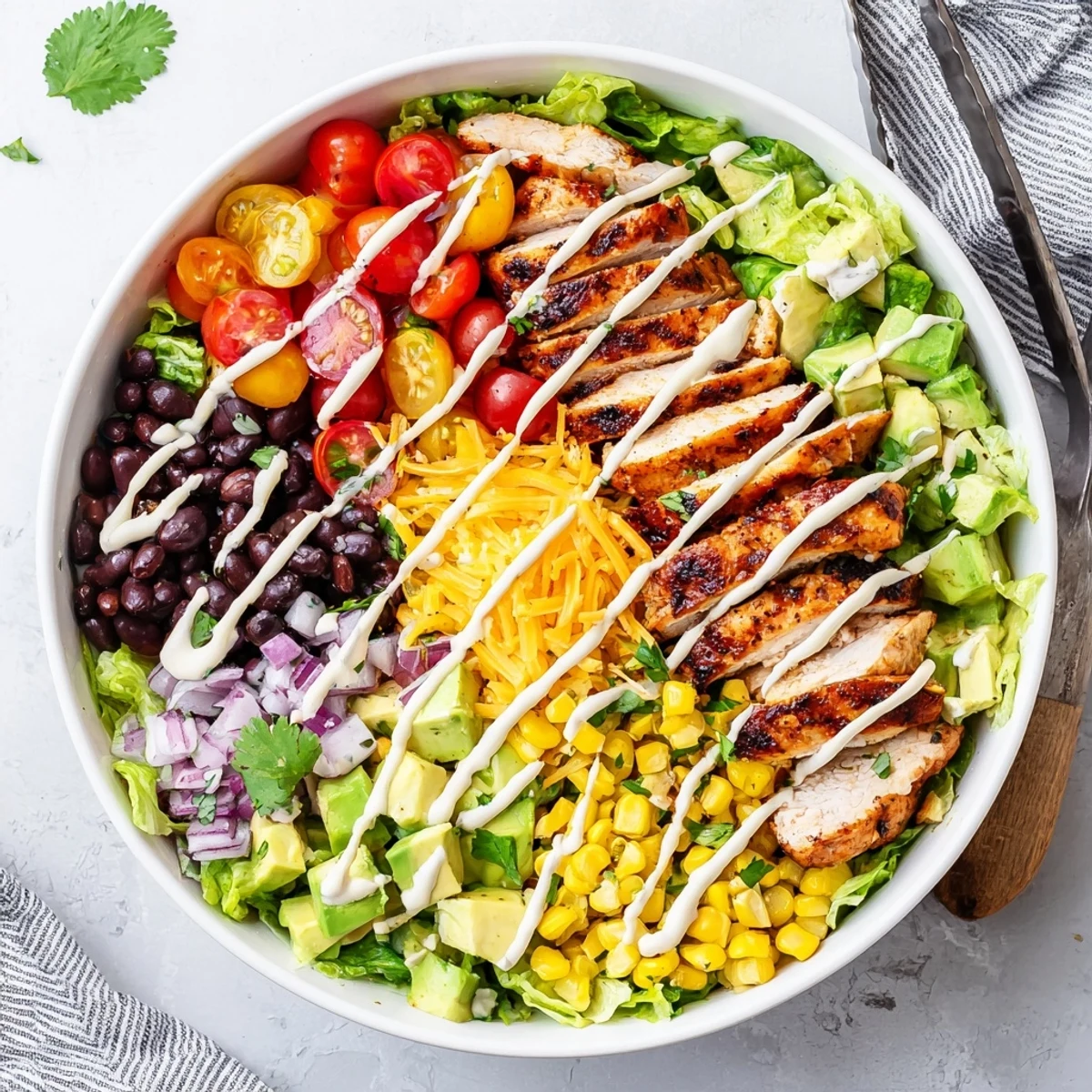 Vibrant chopped salad bowl with succulent grilled BBQ chicken, corn, black beans, and creamy dressing