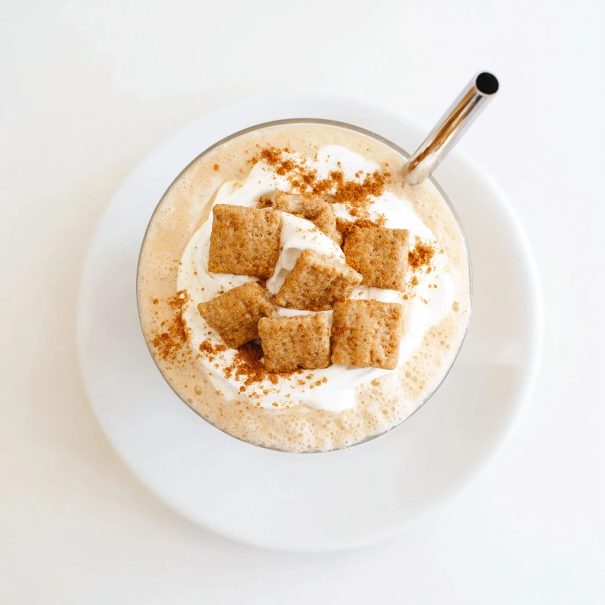 Frosty glass of Cinnamon Toast Crunch Frappe topped with whipped cream and cereal pieces
