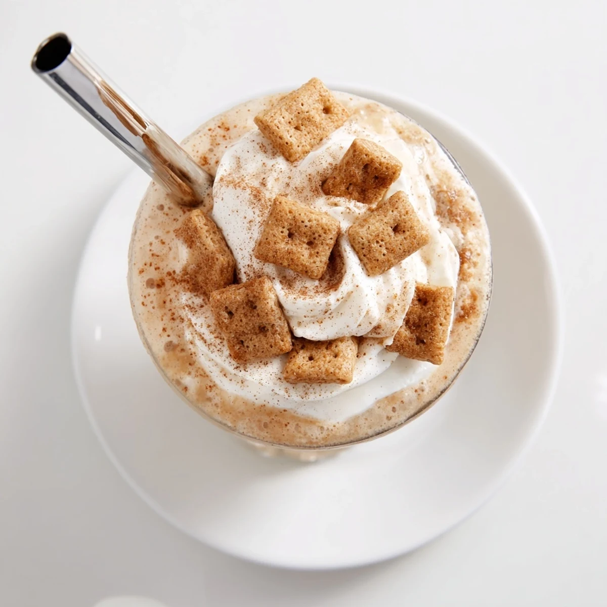 Tall glass filled with swirled Cinnamon Toast Crunch Frappe topped with sweet whipped cream