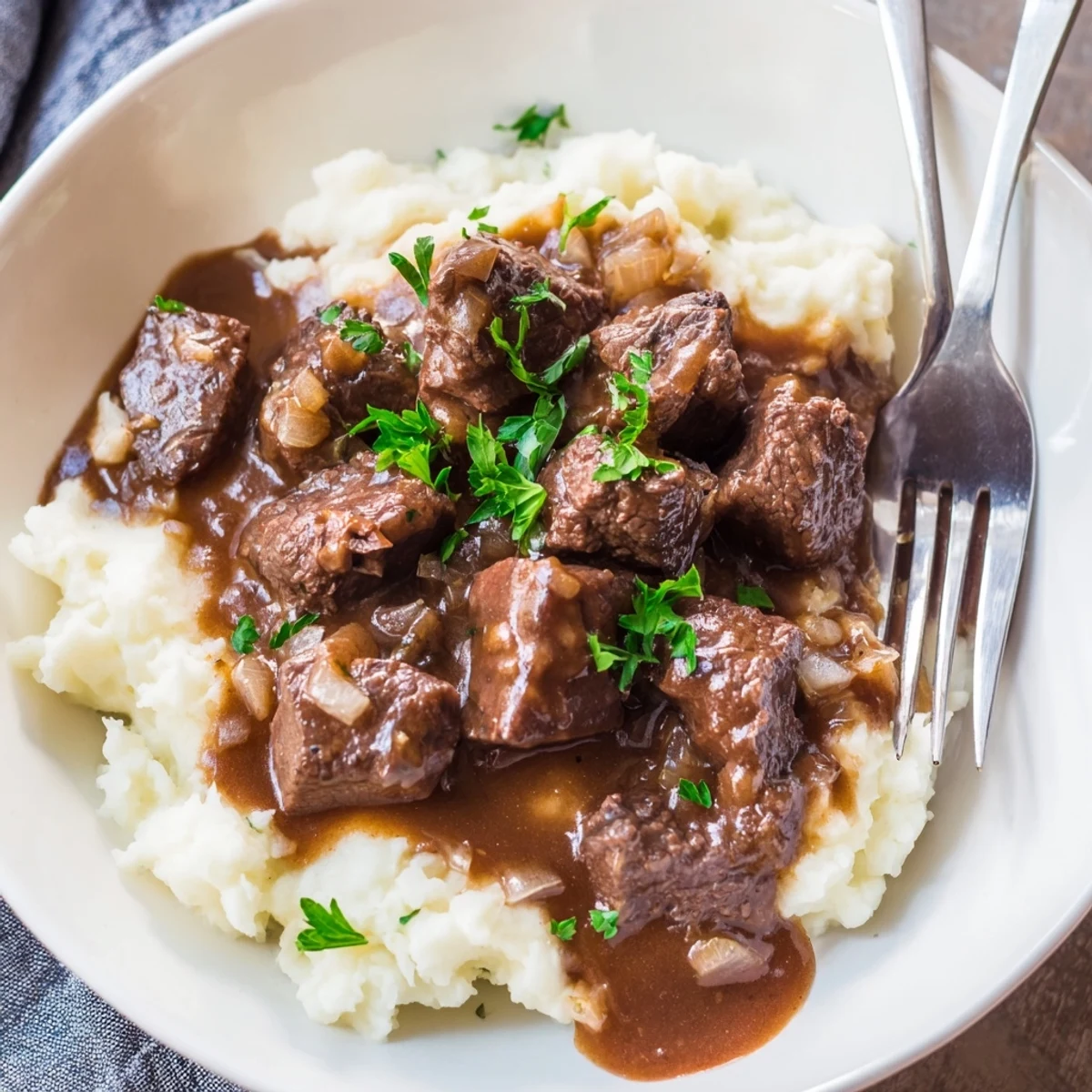 Golden brown beef tips swimming in thick brown gravy, a classic slow cooker beef tips and gravy meal