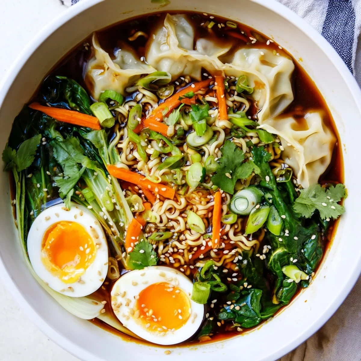 Steaming bowl of dumpling ramen featuring soft-boiled eggs, vibrant fresh spinach, and bok choy in savory broth