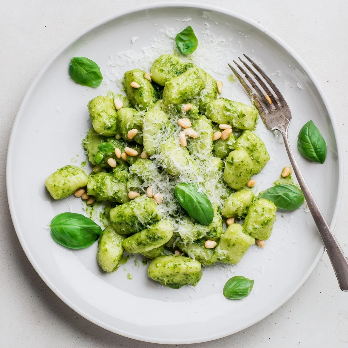 Golden potato gnocchi coated in vibrant green homemade basil pesto sauce