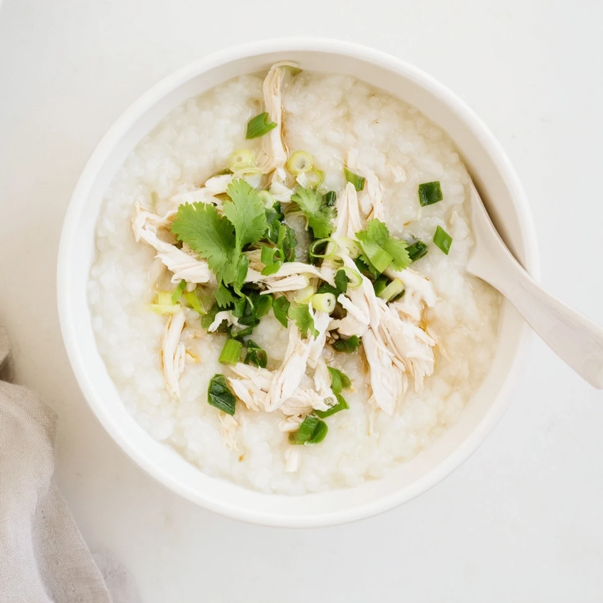 Savory Chinese chicken congee porridge drizzled with sesame oil and soy sauce