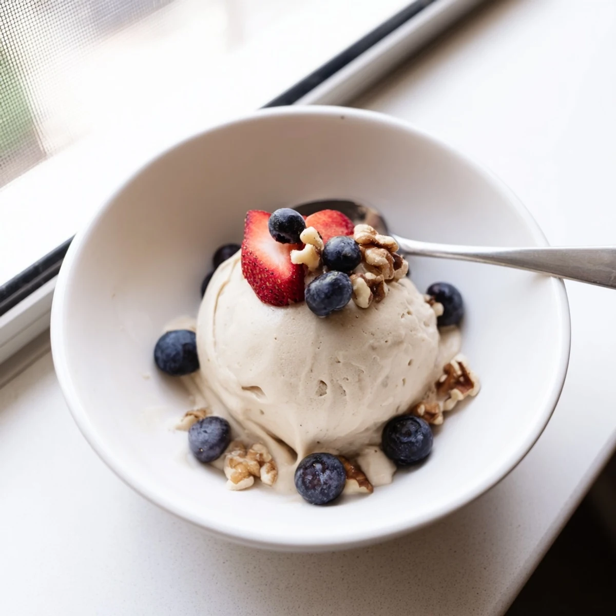 Homemade banana nice cream recipe showing scoops of dairy-free frozen dessert with chocolate chip garnish