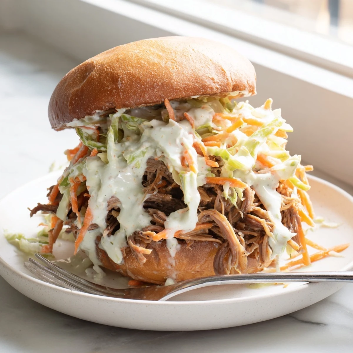 Juicy Alabama white sauce pulled lamb sliders piled high with crunchy creamy slaw on toasted buns