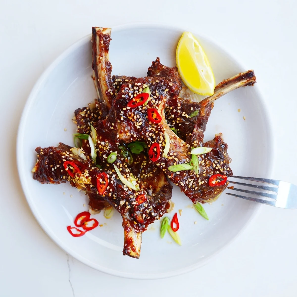Caramelized Korean BBQ lamb ribs charred on the grill with a bright yuzu citrus squeeze