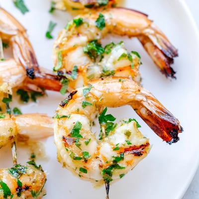 Freshly grilled Lemon Garlic Shrimp Skewers served over fluffy white rice with lemon wedges on the side.